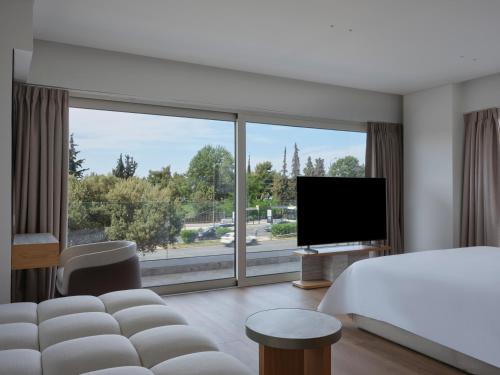 a hotel room with a bed and a large window at Nur Riviera Aparthotel in Athens