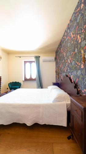 a bedroom with a large bed with a floral wallpaper at Le Case Resort in Macerata