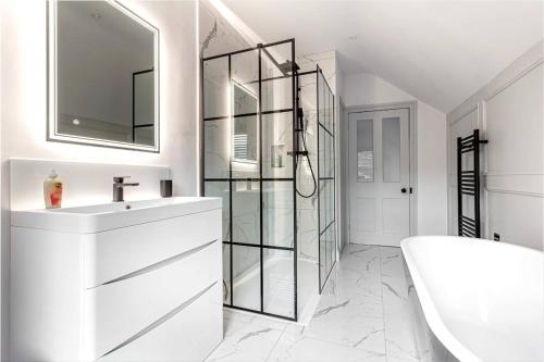 ein weißes Badezimmer mit Waschbecken und Spiegel in der Unterkunft Zest Homes 34 Barton Road in Hereford