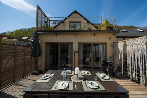 a patio with a table on a balcony at Le Jardin Des Secrets "Gites et chambres à louer" in Namur