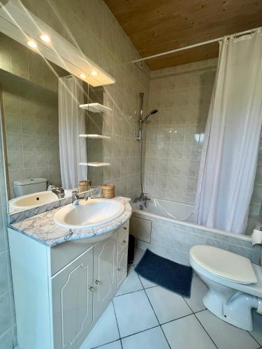 une salle de bain avec un lavabo, des toilettes et une baignoire dans l'établissement Gites de la Mouette Le Bigorneau nid cotier 2 personnes, à Ravenoville