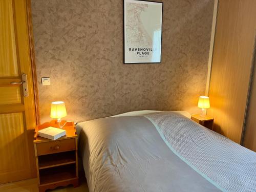 une chambre avec un lit avec deux lampes et un tableau au mur dans l'établissement Gites de la Mouette Le Bigorneau nid cotier 2 personnes, à Ravenoville