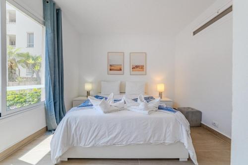 カジャオ・サルバヘにあるOcean Breeze Apartmentsの白いベッドルーム(ランプ2つ付)