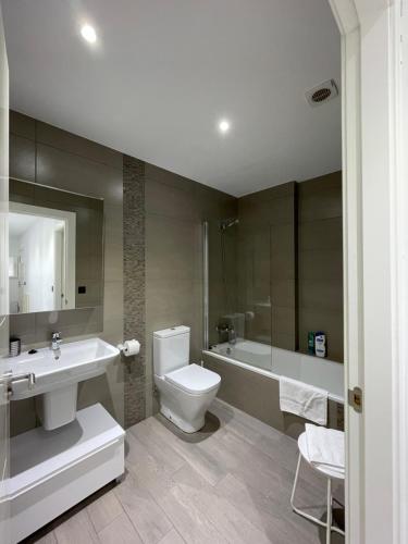 a bathroom with a sink and a toilet and a tub at Apartamento Rústico in Ochandiano