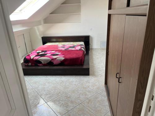 une chambre avec un lit avec une couette rouge dans l'établissement Appartement F3 meublés à 2 stations de l'aéroport Charles de Gaulles , Parc des expositions, à Villepinte