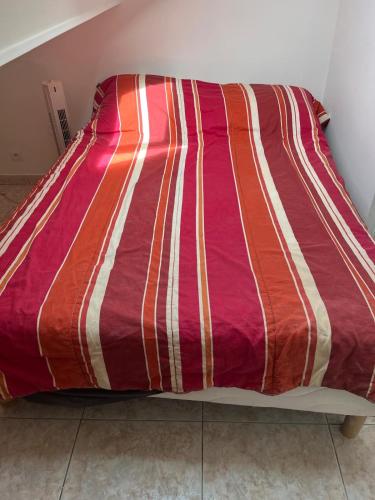- un lit avec une couette rayée colorée dans l'établissement Appartement F3 meublés à 2 stations de l'aéroport Charles de Gaulles , Parc des expositions, à Villepinte