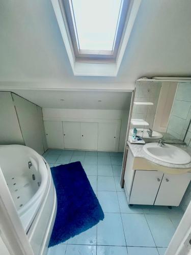 La salle de bains est pourvue d'une lucarne, d'une baignoire et d'un lavabo. dans l'établissement Appartement F3 meublés à 2 stations de l'aéroport Charles de Gaulles , Parc des expositions, à Villepinte