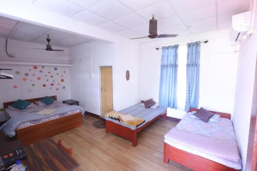 a room with two beds and a bed and a couch at Bhaskar Homestay in Dibrugarh