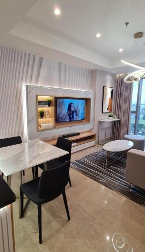 a living room with a table and a tv at Minimalist Designer Style Apartement Branz BSD 1BR in Samporo