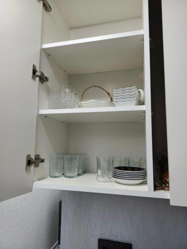 a white cupboard with plates and dishes on it at The Mountain A-Frame Qusar in Yuxarı Lǝgǝr