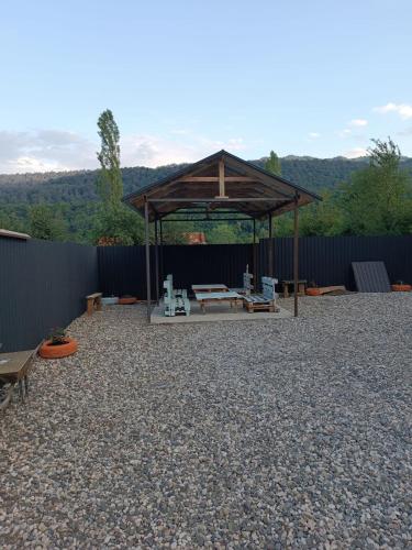 a gazebo with a picnic table and benches at The Mountain A-Frame Qusar in Yuxarı Lǝgǝr