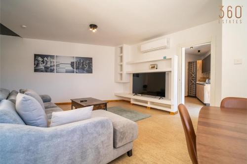 a living room with a couch and a television at 2BR Penthouse with Huge Terrace in peaceful Gozo by 360 Estates in Sannat