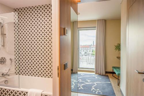 a bathroom with a shower and a tub at NH Porto Jardim in Porto