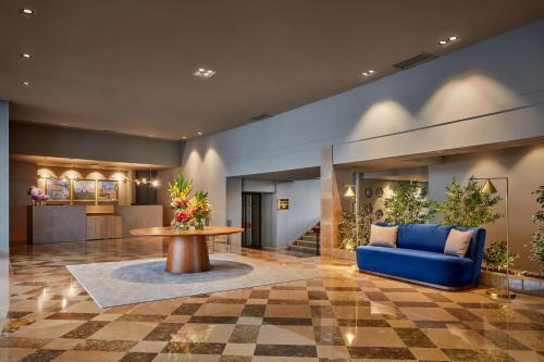 a lobby with a blue couch and a table at NH Sintra Centro in Sintra