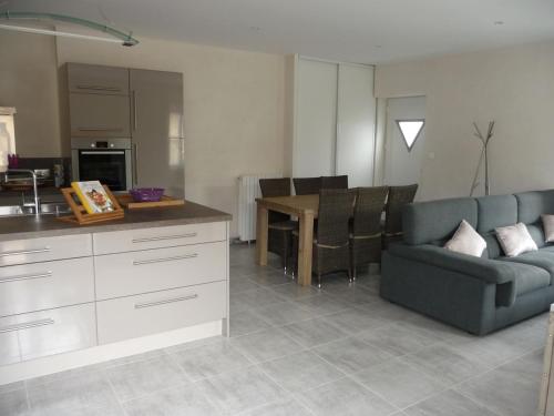 une cuisine et un salon avec un canapé et une table dans l'établissement Maison de ville tout confort, à La Teste-de-Buch