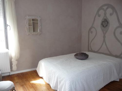 une chambre avec un lit sur lequel est assis un chat dans l'établissement Maison de ville tout confort, à La Teste-de-Buch