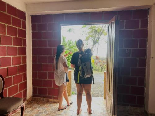 two girls standing in a room looking at a door at Hotel Destino del Pacifico - Bahia Solano in El Valle