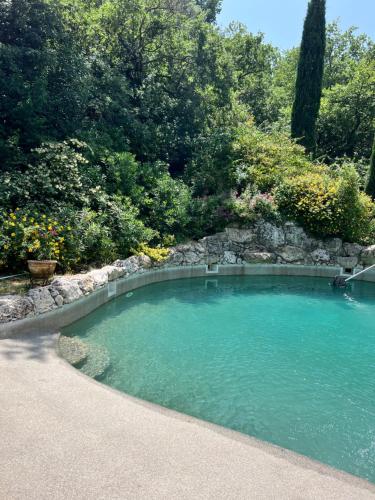 une grande piscine d'eau avec un mur en pierre dans l'établissement Lovely stay in provence, à Mimet