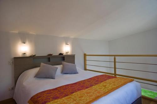 a bedroom with a large bed with two pillows at Les Chambres Buissonnieres in Ladoix Serrigny