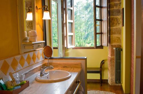 a bathroom with a sink and two windows at Casona de San Pantaleón de Aras in San Pantaleón de Aras