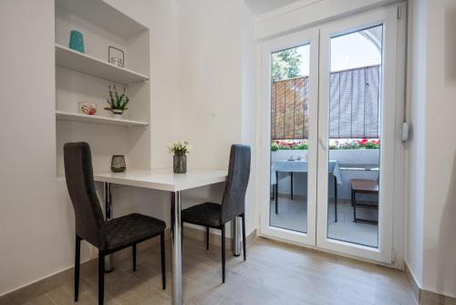 a dining room with a table and chairs and a window at Apartmani Mandić in Neum