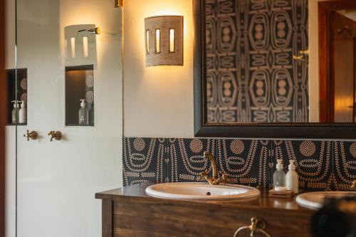 a bathroom with two sinks and a mirror at Lalibela Game Reserve Lentaba Safari Lodge in Paterson