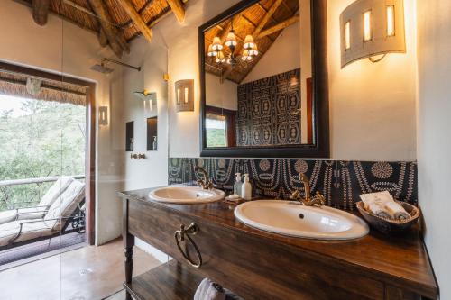 a bathroom with two sinks and a large mirror at Lalibela Game Reserve Lentaba Safari Lodge in Paterson