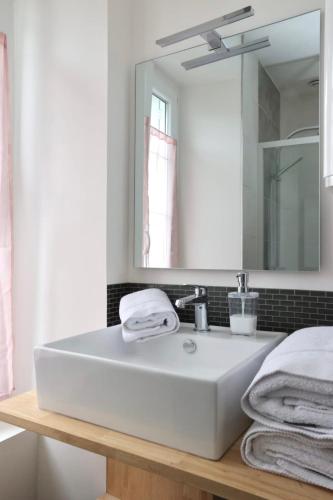 une salle de bain avec un lavabo blanc et un miroir dans l'établissement L'Ocre- Cosy street studio, à Pontivy