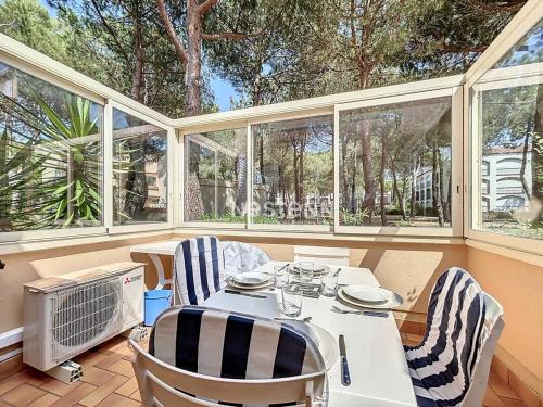 une salle à manger avec une table, des chaises et des fenêtres dans l'établissement 3653-Studio climatisé avec terrasse à 400m de la plage, à Argelès-sur-Mer