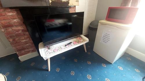 a fireplace in a living room with a blue floor at Phoenix Nights Guest House in Barrow in Furness