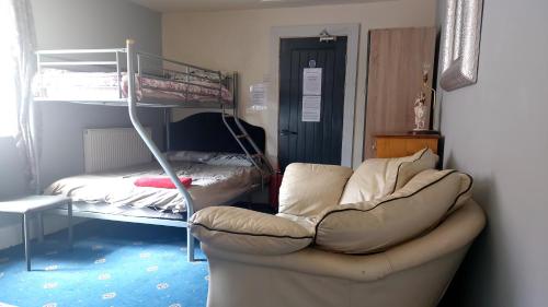 a room with a couch and a bunk bed at Phoenix Nights Guest House in Barrow in Furness