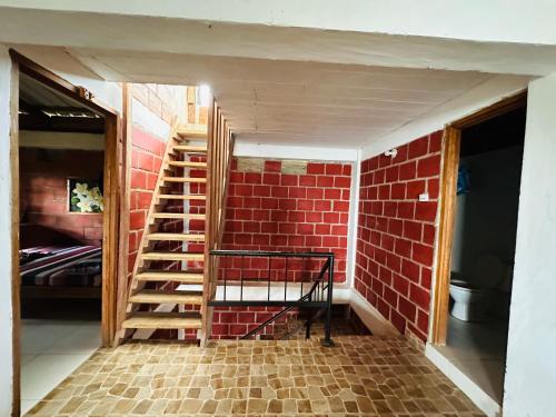 a room with a brick wall and a staircase at Hotel Destino del Pacifico - Bahia Solano in El Valle