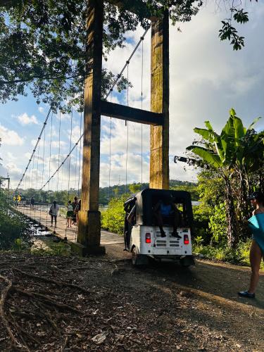 a small white car parked on a suspension bridge at Hotel Destino del Pacifico - Bahia Solano in El Valle