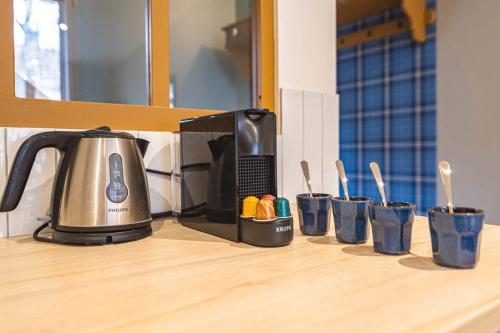 un comptoir de cuisine avec une bouilloire et des tasses bleues dans l'établissement Millésime Duplex, Centre de Reims, à Reims