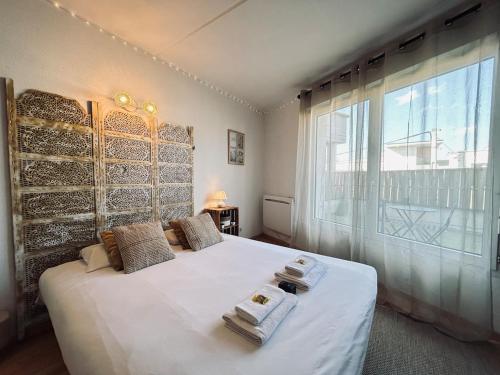 a bedroom with a white bed with a large window at Bruyant studio proche centre, terrasse et parking in Reims