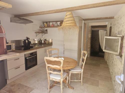 une cuisine avec une table et des chaises en bois dans l'établissement La croisée des destins, à Viviers