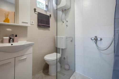 a bathroom with a toilet and a sink and a shower at Apartmani Mandić in Neum