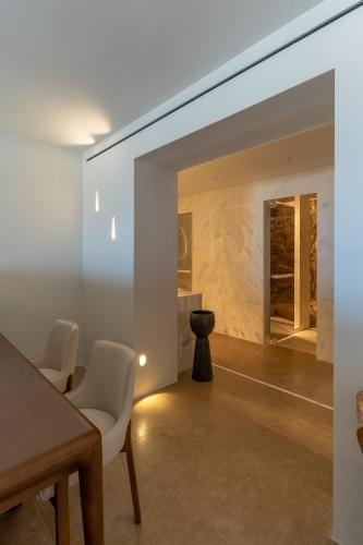 a dining room with white chairs and a table at Νumi Boutique Hotel in Mýkonos City