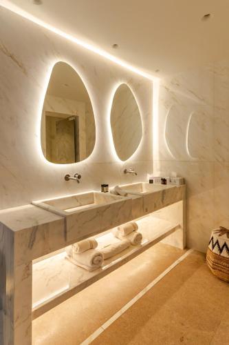 a bathroom with two sinks and a large mirror at Νumi Boutique Hotel in Mýkonos City