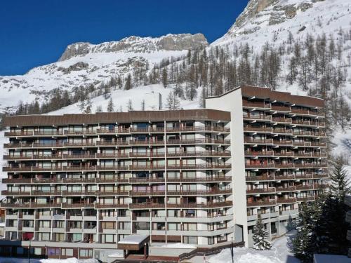 un grand bâtiment en face d'une montagne enneigée dans l'établissement Studio cosy pour 4 avec balcon et wifi à Val-d'Isère - FR-1-694-364, à Val dʼIsère