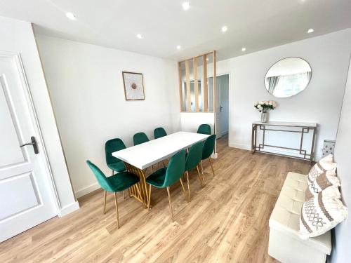 une salle à manger avec une table et des chaises vertes dans l'établissement PARIS à 15 minutes- Grand Appartement 5 Pièces, à Vitry-sur-Seine
