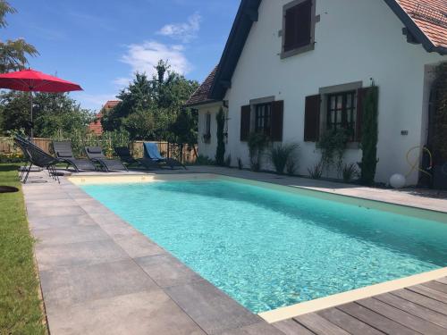 a swimming pool in front of a house at Les Chambres Chez Christine in Ottrott