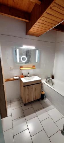 une salle de bain avec un lavabo et une baignoire dans l'établissement Le Duplex Charentais, à Saint-Jean-dʼAngély