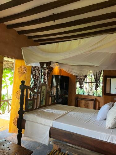 a bedroom with a large bed with a canopy at Sazani Beach Lodge and Tidal Lounge in Nungwi