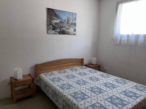 une chambre avec un lit avec une couette dessus dans l'établissement Appartement confortable, balcon, Cauterets - FR-1-812-6, à Cauterets
