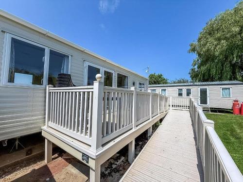 a house with a white railing and a deck at Beautiful 8 Berth Caravan At Heacham Beach In Norfolk Ref 21056C in Heacham