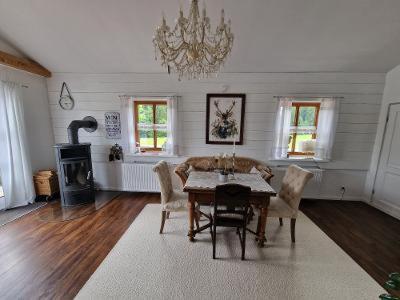 a dining room with a table and chairs and a chandelier at Ferienwohnung am Golfplatz in Scheidegg
