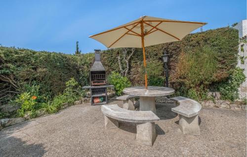 a table and benches with an umbrella and a grill at Awesome Home In Tossa De Mar With Wifi in Tossa de Mar