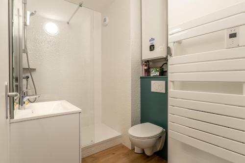une salle de bain blanche avec des toilettes et un lavabo dans l'établissement Studio vue Vieux port Pornic -A011, à Pornic