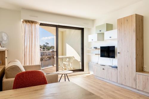 un salon avec une table à manger et une télévision dans l'établissement Studio vue Vieux port Pornic -A011, à Pornic